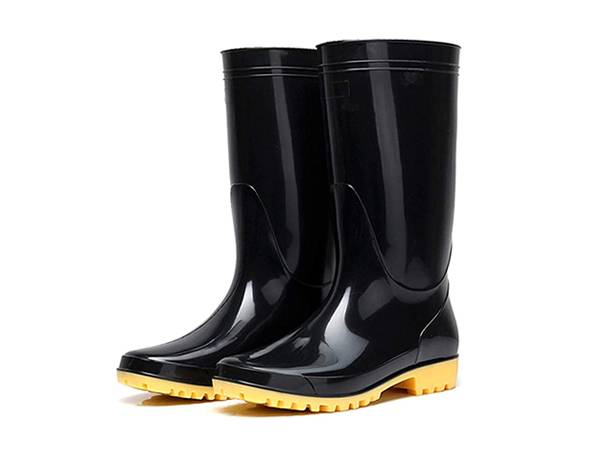 A pair of rain boots with yellow sole is displayed.