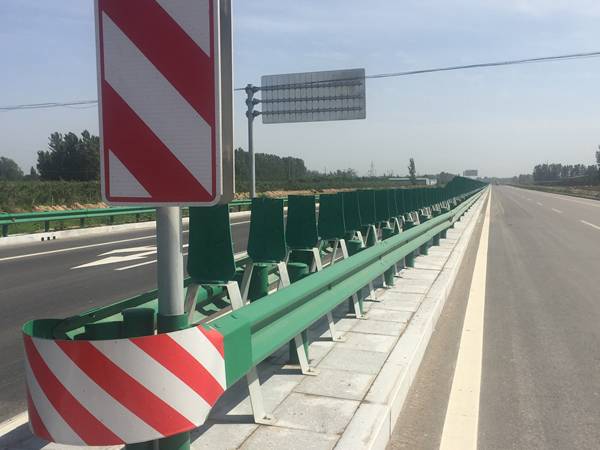 Red and white reflective tape is pasted on highway barrier and post.
